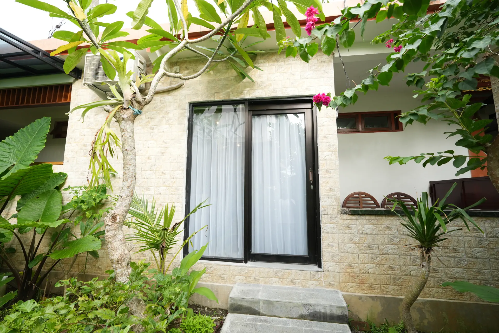 Tranquil tropical garden at The Pageh Guesthouse Ubud with rooms and private balconies, Bali
